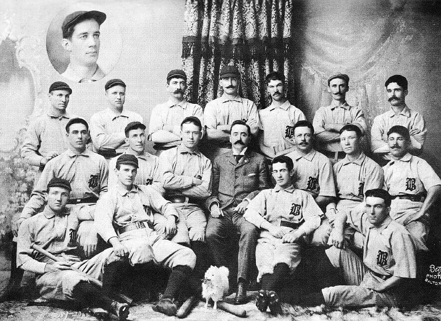 Formal studio portrait of the 1896 Baltimore Orioles baseball team posed in uniform with a large inset portrait above them.