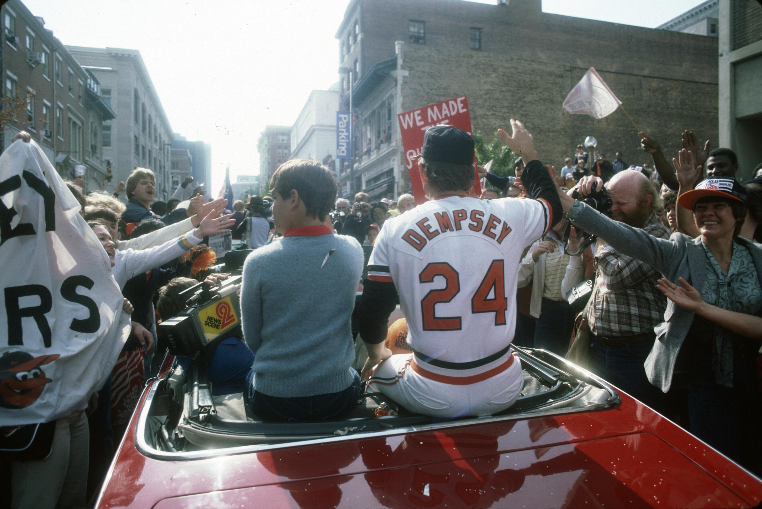 Rick Dempsey, wearing jersey number 24, waves to cheering fans