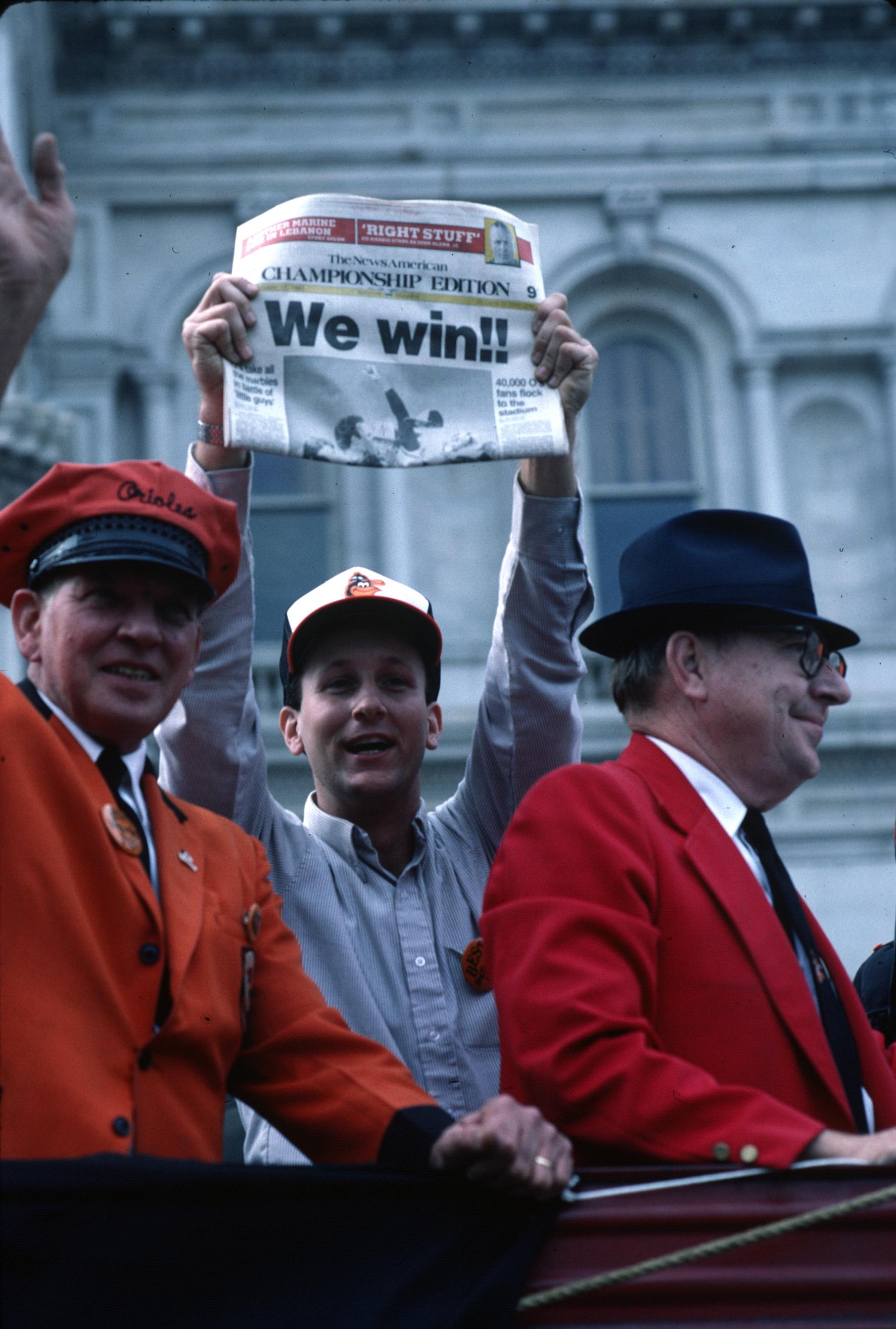 Fan holds up a newspaper reading “We win!!”