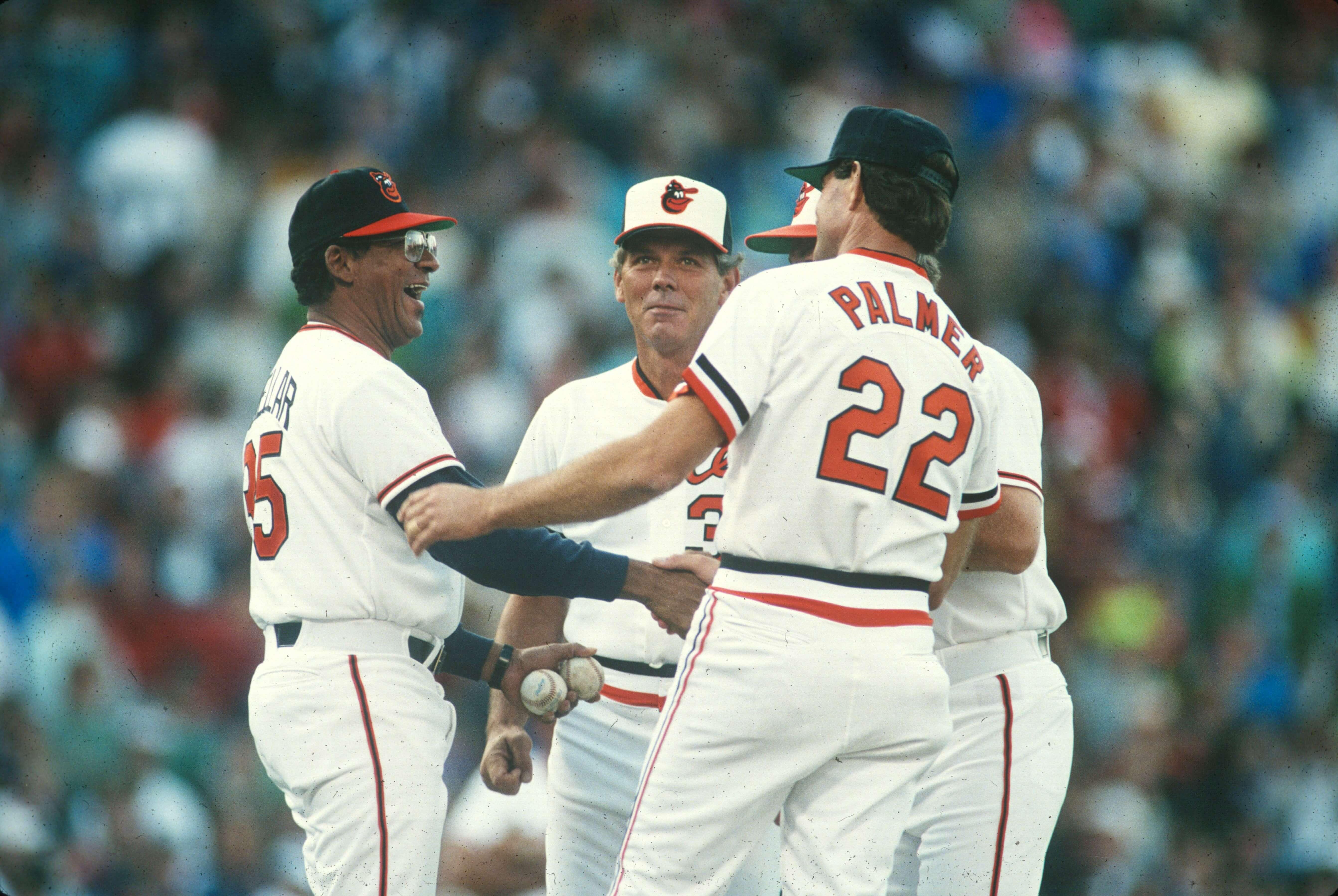 Jim Palmer stands on the pitcher’s mound with other players