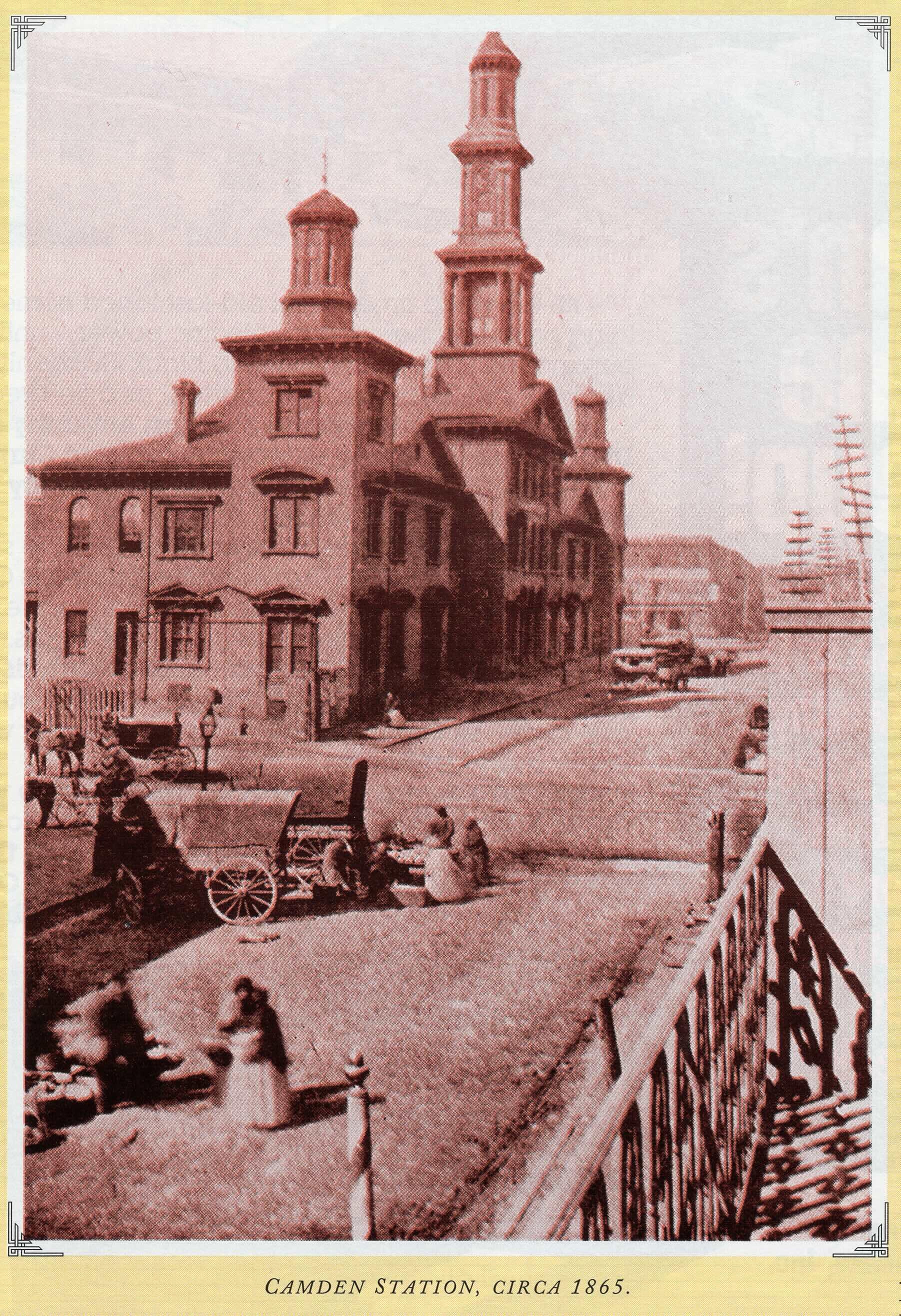 Historic illustration of Camden Station in Baltimore around 1865 with horse-drawn wagons and pedestrians on the street.